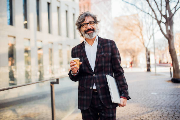 istock Businessman holding laptop and disposable cup 1158233153