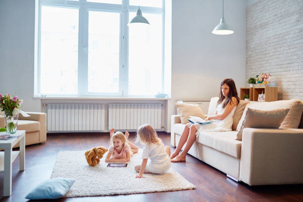istock Mother reading book near daughters 1158233423