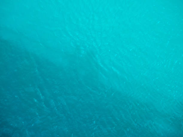 istock shadows of people on a turquoise water surface 1158236379