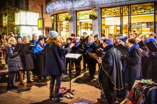 рождественский хор поет по ночам - caroler стоковые фото и изображения