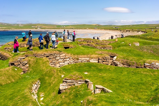 Orkney, Scotland - People visiting the stone remains of the Neolithic village of Skara Brae, on the Orkney coast.