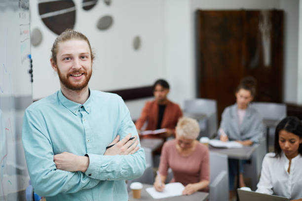 istock Young Male Teacher Posing by Board 1158237391
