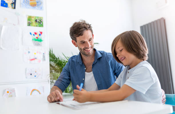 istock Father and son doing homework together at home 1158237510