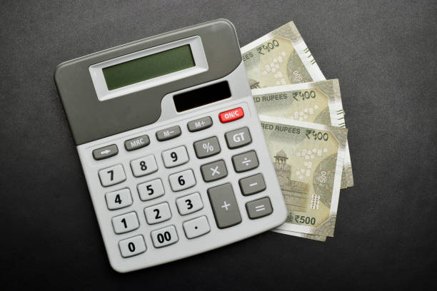 soldi indiani con calcolatrice su sfondo nero strutturato, - value added tax foto e immagini stock