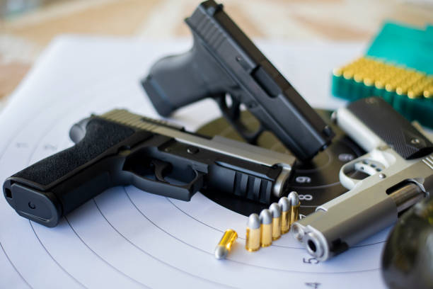 istock Guns with ammunition on paper target shooting   practice 1158237958