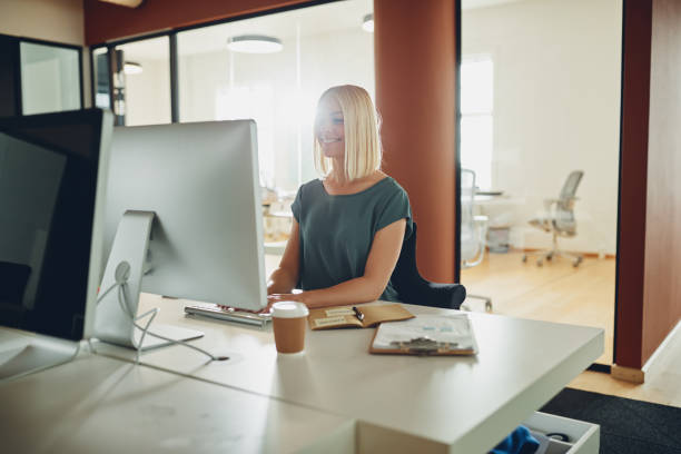 istock Young businesswoman smiling while working online at her office desk 1158237996