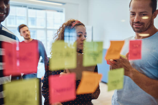 istock Group of designers brainstorming with notes on a glass wall 1158238007
