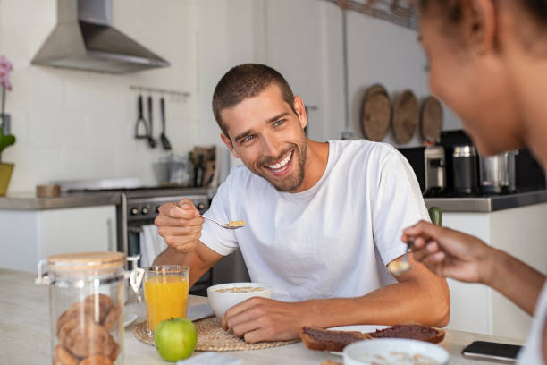 istock Young man eating cereal at breakfast 1158240317