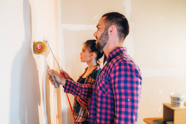 istock Young couple painting wall 1158241012