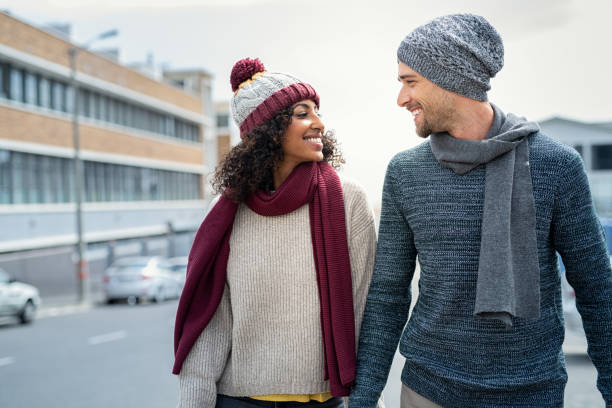 pareja multiétnica enamorada caminando durante el invierno - cardigan men african ethnicity african descent fotografías e imágenes de stock