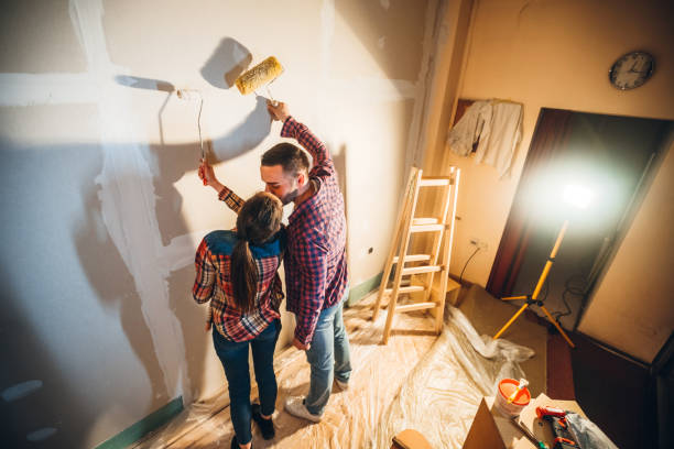 istock Young couple painting wall 1158241248