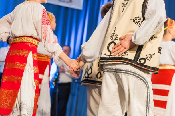 istock Young Romanian dancer hold hand on his back while perform a folk dance in traditional folkloric costume. Folklore of Romania 1158243373