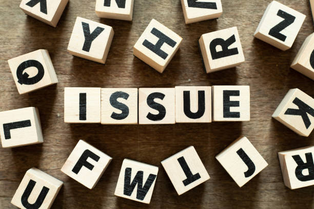 istock Letter block in word issue with another block on wood background 1158244280