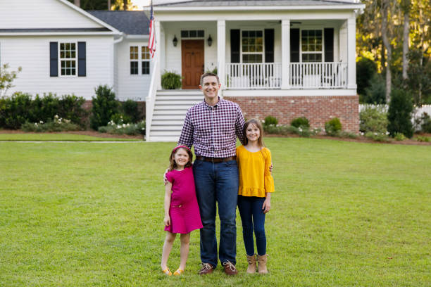 istock dad and two daughters outside their home 1158244663