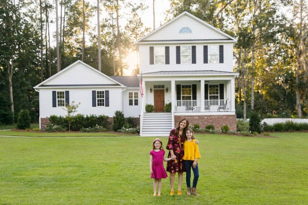 istock mom and two daughters outside their home 1158244690