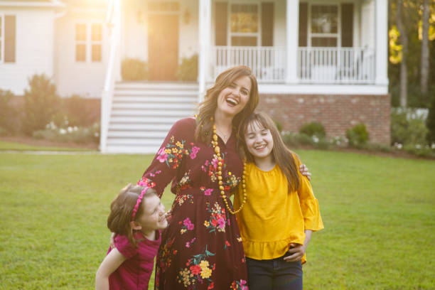 istock mom and two daughters outside their home 1158244767