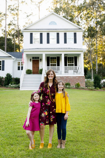 istock mom and two daughters outside their home 1158244811
