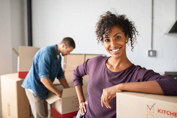 istock Woman leaning on cardboard box while moving house 1158244934