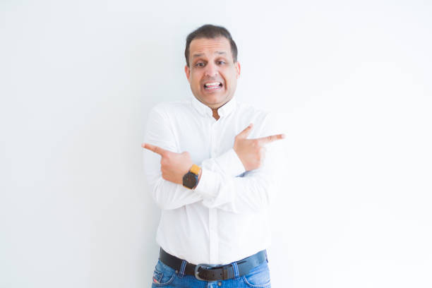 istock Middle age business man smiling and pointing to the side over white background 1158245092
