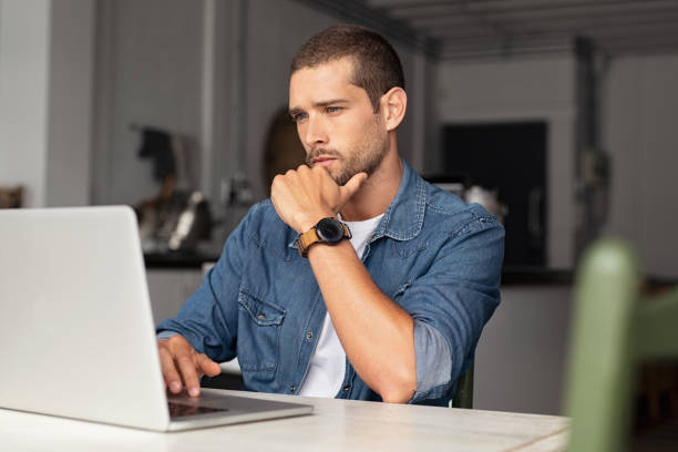 Serious man working on laptop at home