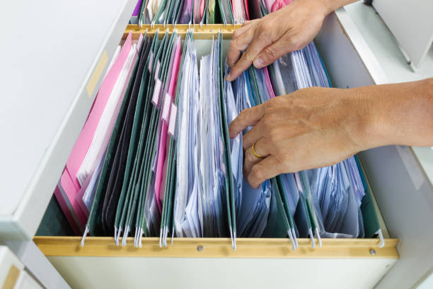 istock Hand of Man Search files document in a file cabinet in work office 1158246887