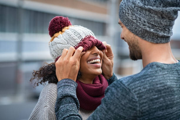 homem e mulher que jogam com tampão do inverno - fun knit hat adult dating - fotografias e filmes do acervo