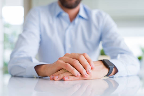 istock Close up of man crossed hands over white table 1158248302