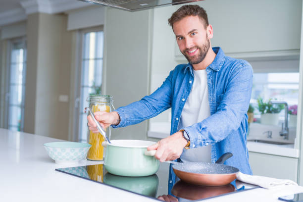 istock Handsome man cooking pasta at home 1158248532