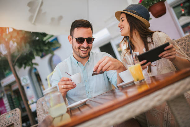 istock Happy young couple shopping online while sitting in a cafe. 1158248544