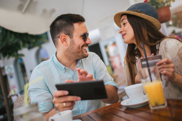 istock Happy young couple shopping online while sitting in a cafe. 1158248550