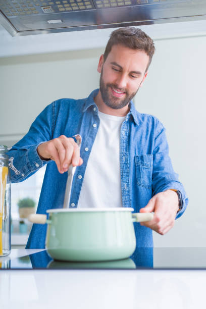 istock Handsome man cooking pasta at home 1158248561