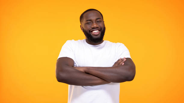istock Smiling black male folded arms looking camera bright background, positive mood 1158248888