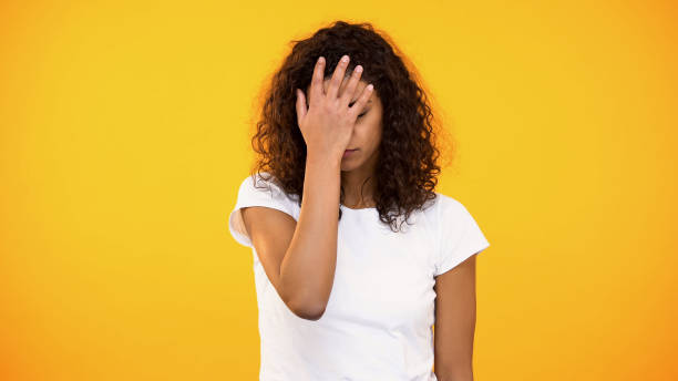 Discontent biracial lady gesturing face palm on camera against yellow background Discontent biracial lady gesturing face palm on camera against yellow background head in hands photos stock pictures, royalty-free photos & images