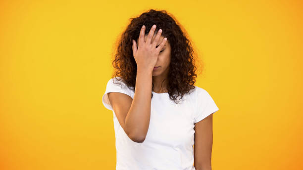 Discontent biracial lady gesturing face palm on camera against yellow background Discontent biracial lady gesturing face palm on camera against yellow background facepalm stock pictures, royalty-free photos & images