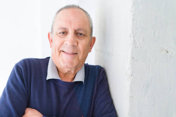 Handsome middle age senior man smiling cheerful, happy and positive leaning over white background with crossed arms