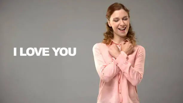 Deaf woman saying love you in sign language, text on background, communication