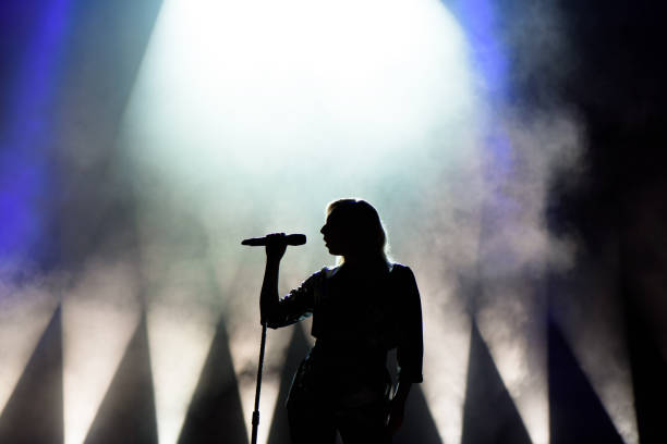 istock Vocalist singing to microphone. Singer in silhouette 1158249699