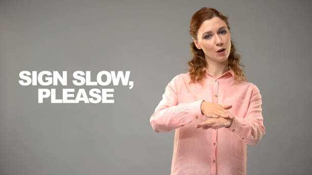istock Woman showing slow please sign in asl, text background, communication for deaf 1158249878