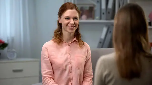 Smiling young lady looking at friend, positive female, communication happiness