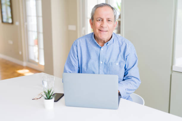 istock Handsome senior man using laptop and smiling 1158249974