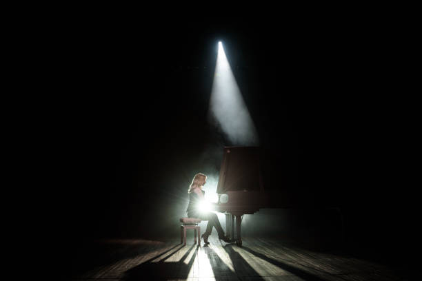 Close up view of a girl plays piano in the concert hall at scene Close up view of a girl plays piano in the concert hall at the scene pianist stock pictures, royalty-free photos & images