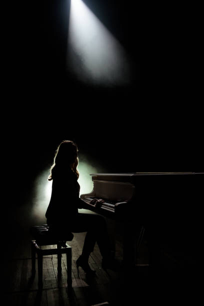 istock Female keyboards player on stage during concert, backlight 1158250014