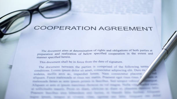 istock Cooperation agreement lying on table, pen and eyeglasses on official document 1158250164