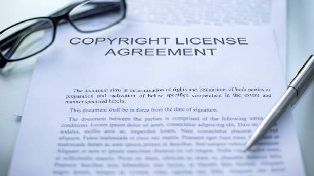 istock Copyright license agreement lying on table, pen and eyeglasses on document 1158250272