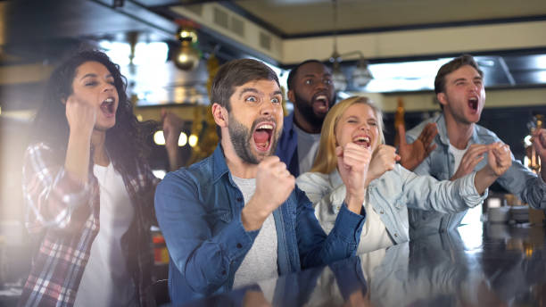 gli appassionati di sport estremamente felici esultano attivamente, celebrando la vittoria nel bar - hanging basket foto e immagini stock