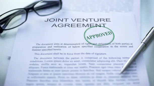 Photo of Joint venture agreement approved, seal stamped on official document, business