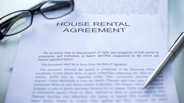 istock House rental agreement lying on table, pen and eyeglasses on official document 1158250570