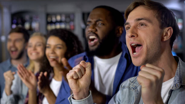 istock Active team supporters cheering for team, clapping hands and shouting, fans 1158250837
