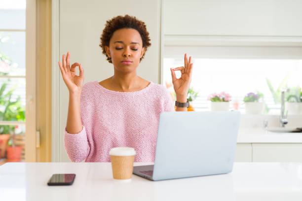 istock Young african american woman working using computer laptop relax and smiling with eyes closed doing meditation gesture with fingers. Yoga concept. 1158251768