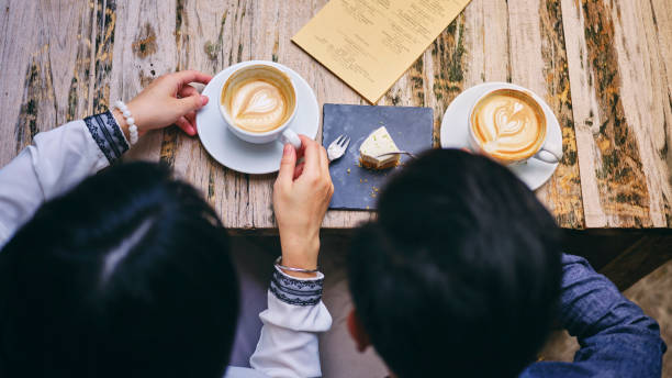Woman Drinking Coffee With Latte Art on a Wooden Table